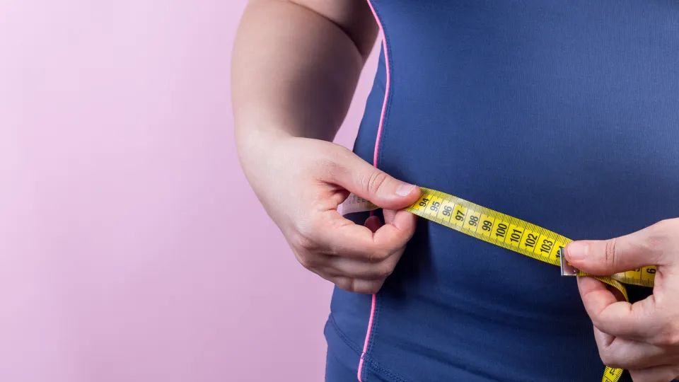 Woman measuring her waist. Photo: iStock
