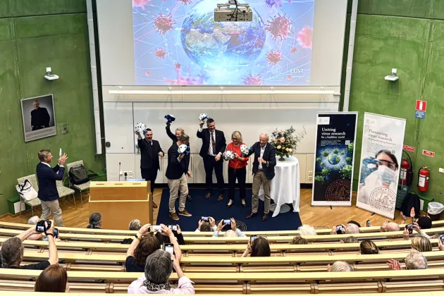 **Photograph from the inauguration, showing speakers from the ceremony breaking apart a virus model. Photo: Agata Garpenlind