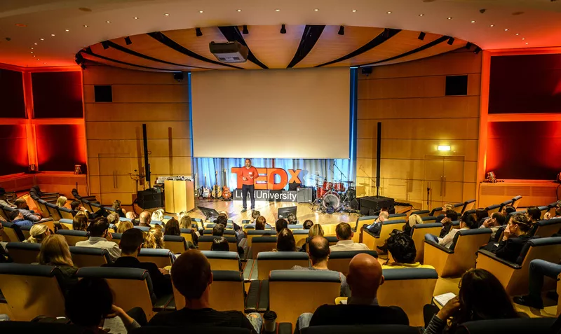 TEDx-talk on stage seen from distance. Photo.